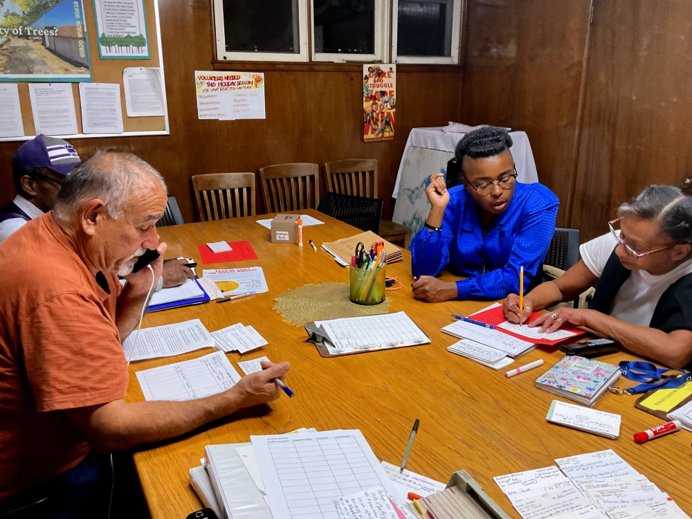 Group of people in an office making calls and taking notes.