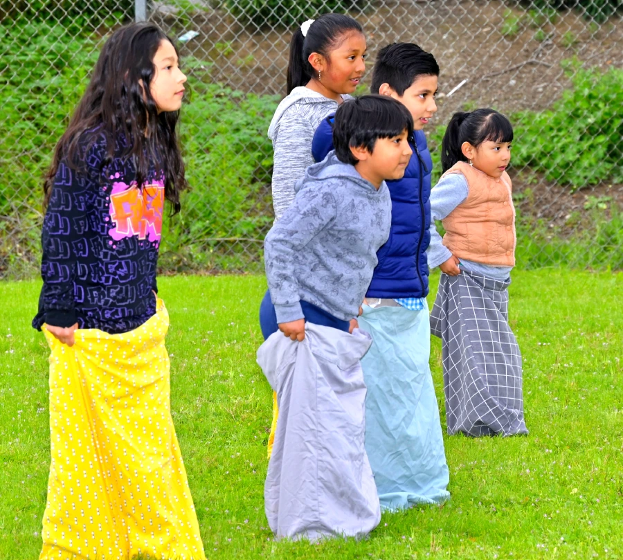 Children standing at the ready for a sack race.